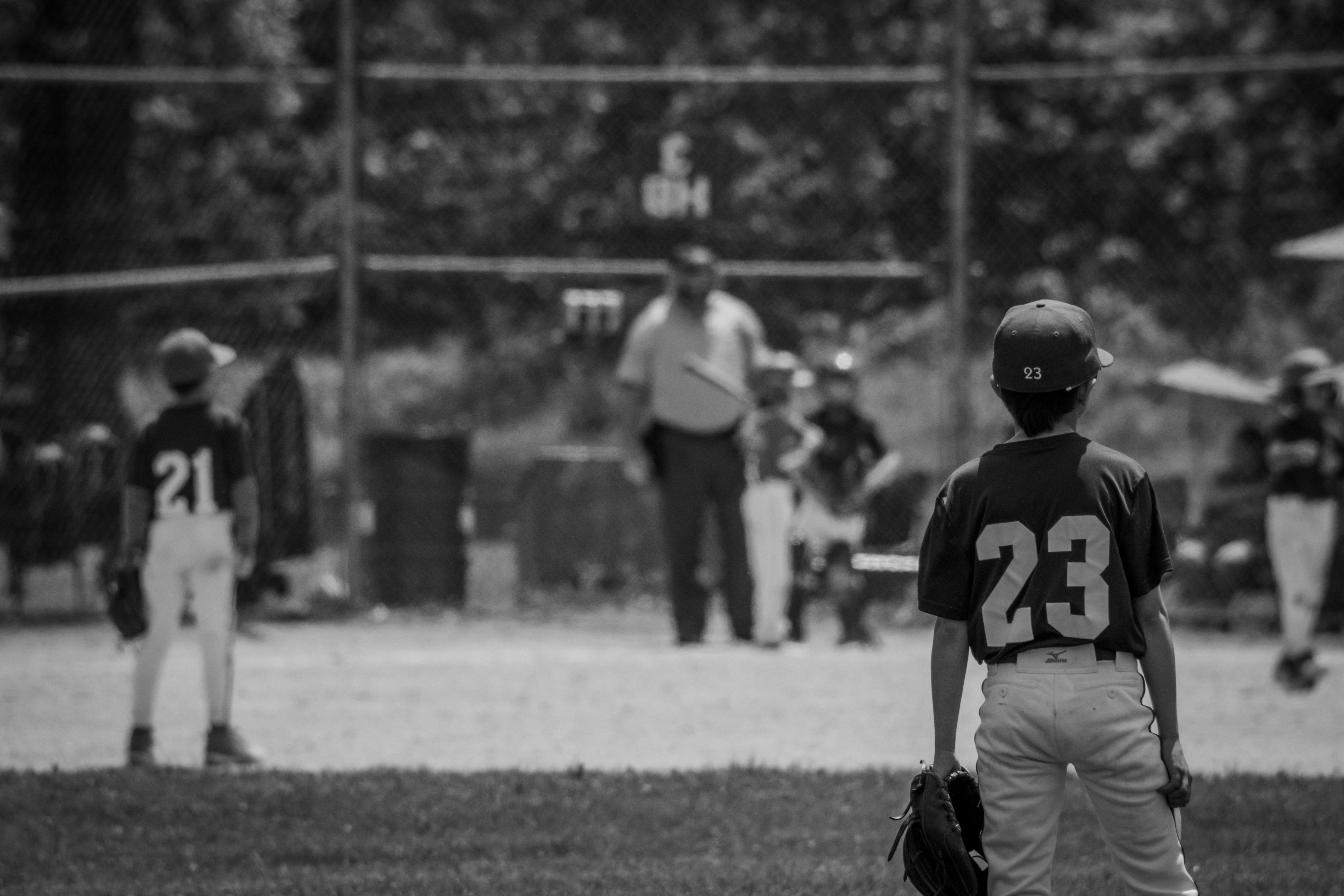 Young player standing on the field watching the game